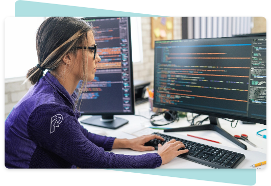 A woman with payology logo in her shoulder using a notebook to code